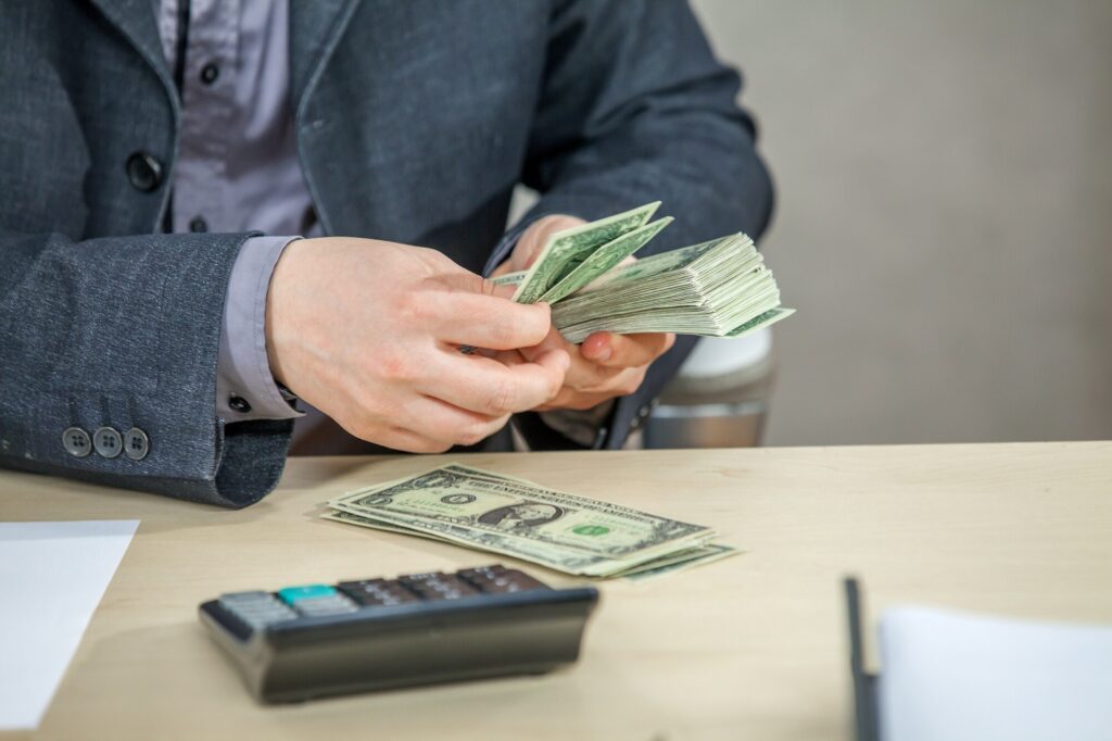 young-businessman-working-from-his-office-counting-cash-money_181624-33459